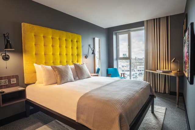 hotel room with a large bed and yellow headboard