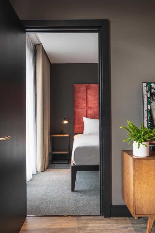 hotel room with a red headboard on the bed