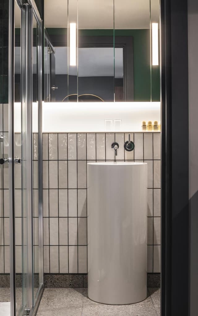 bathroom with a sink, mirror, and shower stall