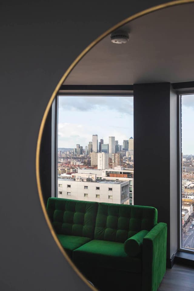 green couch in front of a view of the city
