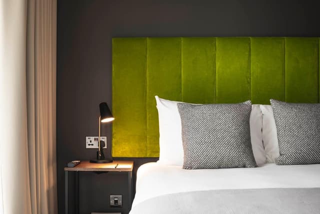 close up of a bed with a green headboard