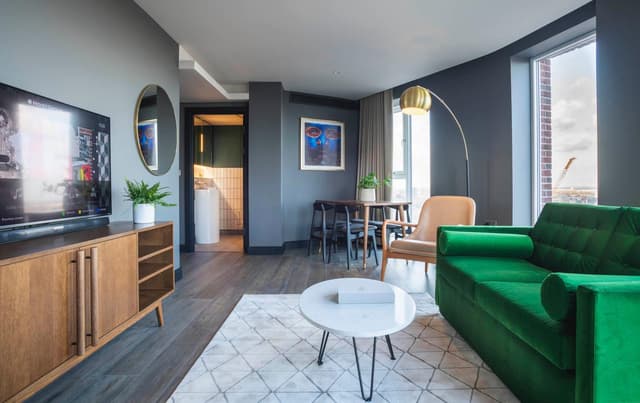 living room with a green couch and a flat screen tv
