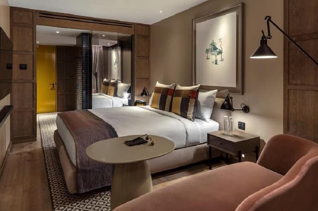 hotel room with two beds and a small table in front of the bed
