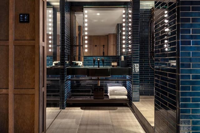 photo of a bathroom with blue tiles and a vanity