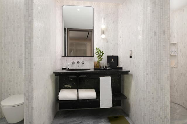 bathroom with a toilet, sink, and shower stall