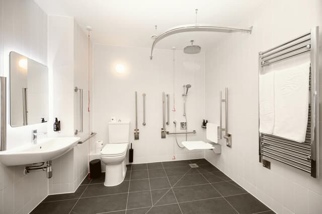 bathroom with a toilet, sink, and shower stall