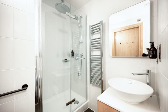 bathroom with a white sink and a glass shower stall