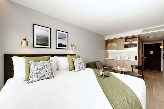hotel room with a bed and kitchen in the background