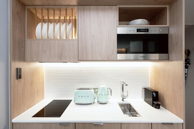 small kitchen with light wood cabinets and white countertops