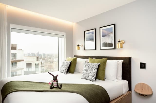 bedroom with a large bed and a view of the city