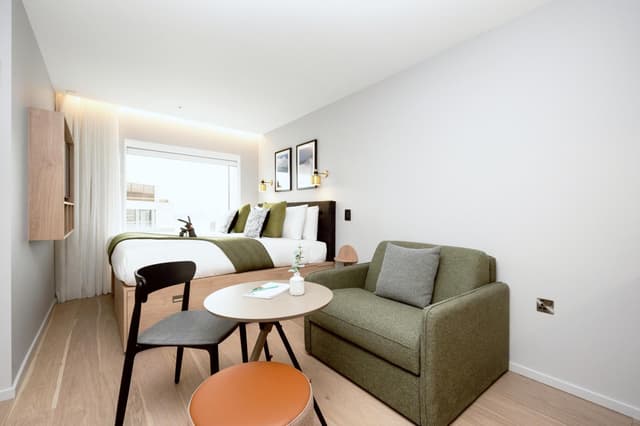 hotel room with a couch, chair, and bed