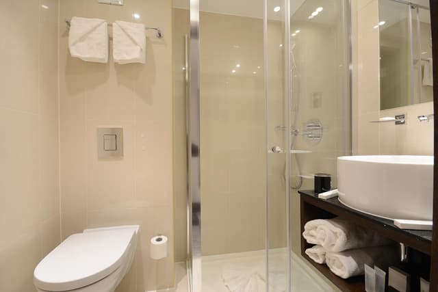 bathroom with a toilet, sink, and shower stall