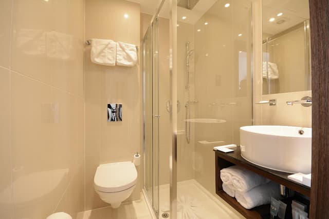 bathroom with a toilet, sink, and shower stall