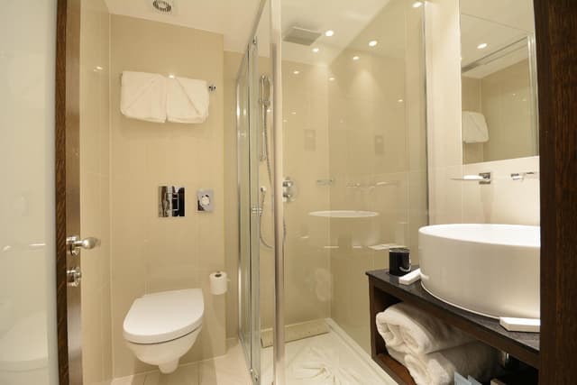 bathroom with a toilet, sink, and shower stall