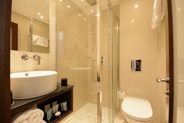 bathroom with a toilet, sink, and shower stall
