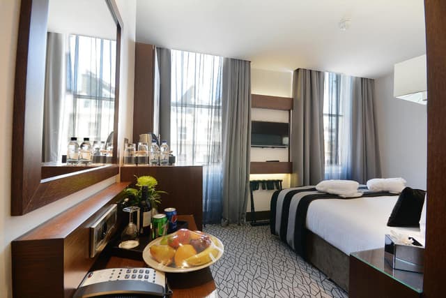 hotel room with a bed, desk, and television