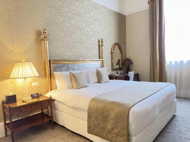 hotel room with a king size bed and gold accents