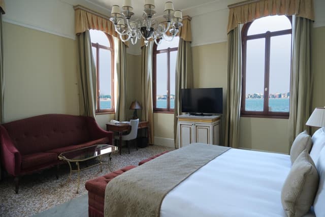 hotel room with a bed, couch, and chandelier