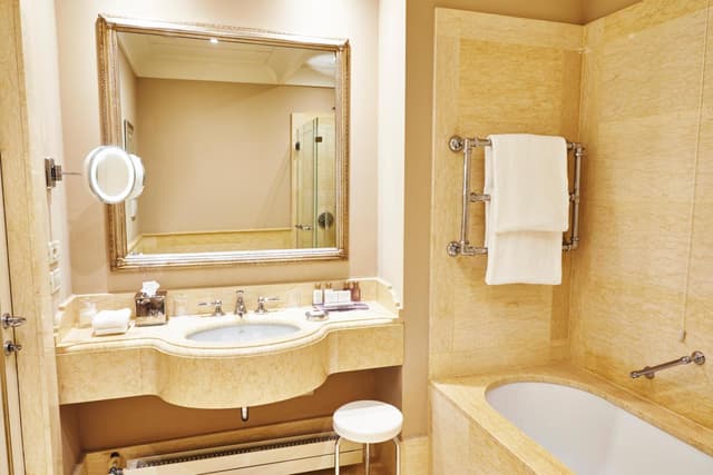 bathroom with a bathtub, sink, and mirror