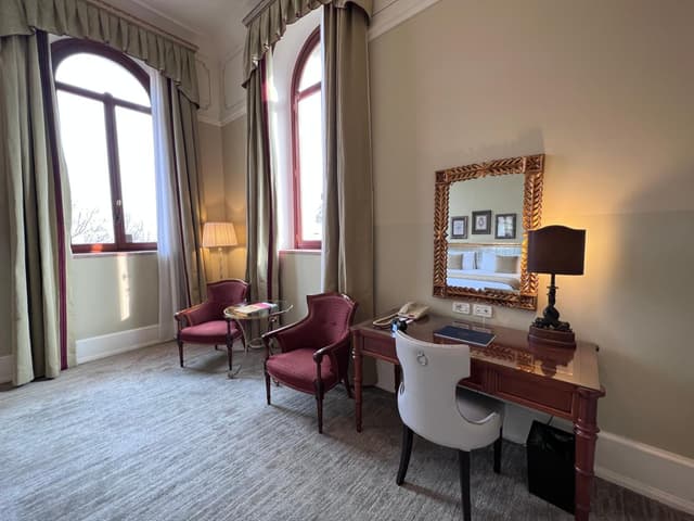 room with two chairs, a desk and a mirror