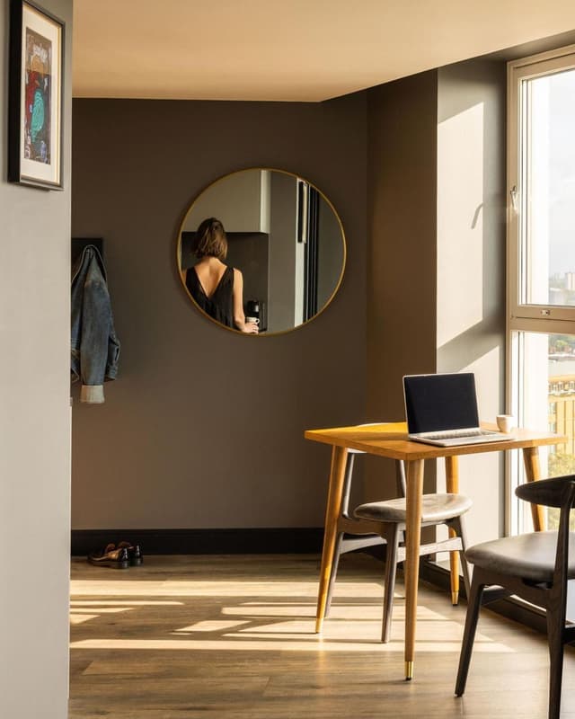 woman taking a photo of herself in a round mirror