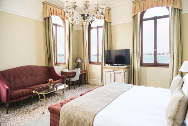 hotel room with a bed, couch, and television