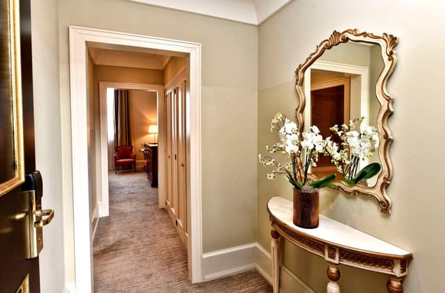 hallway with a vase of flowers on the side table