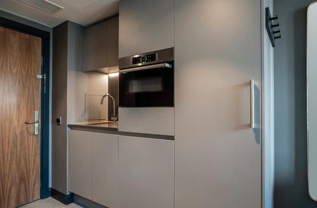 kitchen with a microwave built into the wall and cupboards