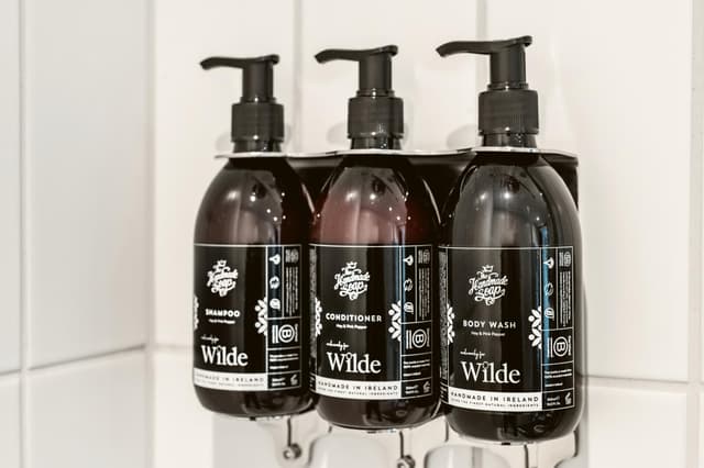 lot of soaps on the shelf in the bathroom
