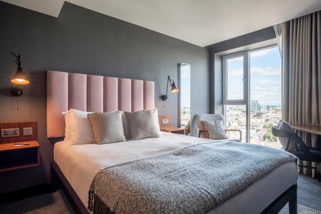 bedroom with a large bed and a view of the city
